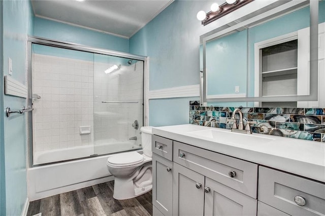 full bathroom featuring tasteful backsplash, combined bath / shower with glass door, toilet, wood finished floors, and vanity