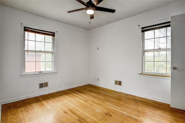 spare room featuring visible vents, light wood-style flooring, and plenty of natural light