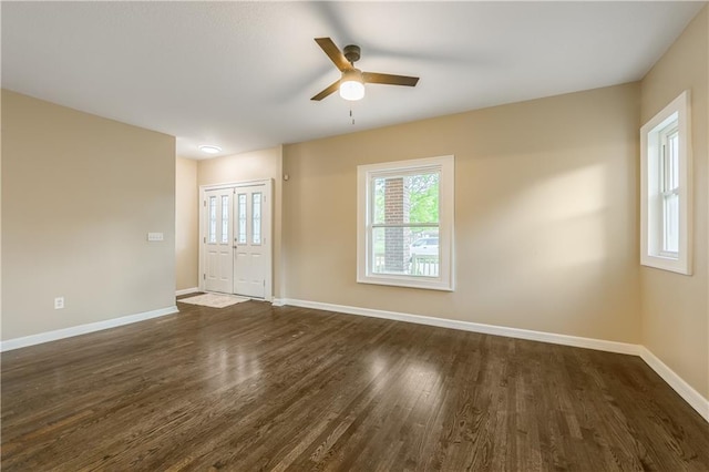 empty room with dark wood finished floors, ceiling fan, and plenty of natural light