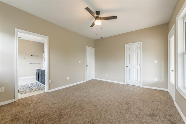 unfurnished bedroom with baseboards, ceiling fan, connected bathroom, and carpet
