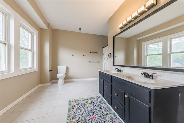 bathroom featuring toilet, baseboards, and a sink