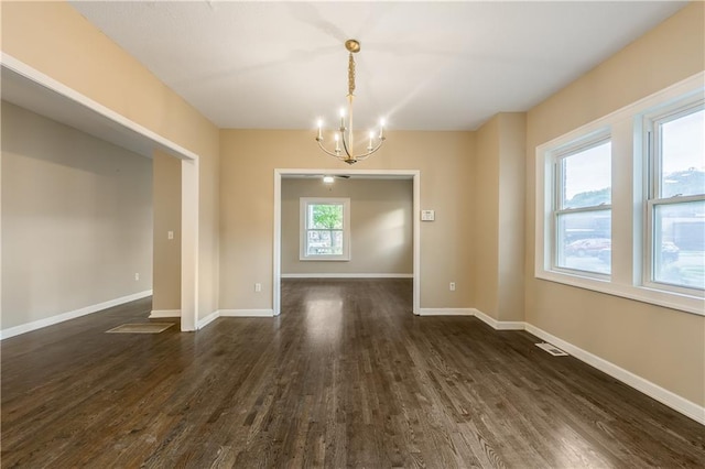 unfurnished dining area featuring an inviting chandelier, visible vents, dark wood-style floors, and baseboards