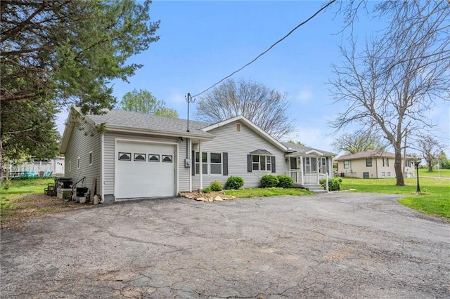 ranch-style house featuring aphalt driveway, covered porch, and a garage