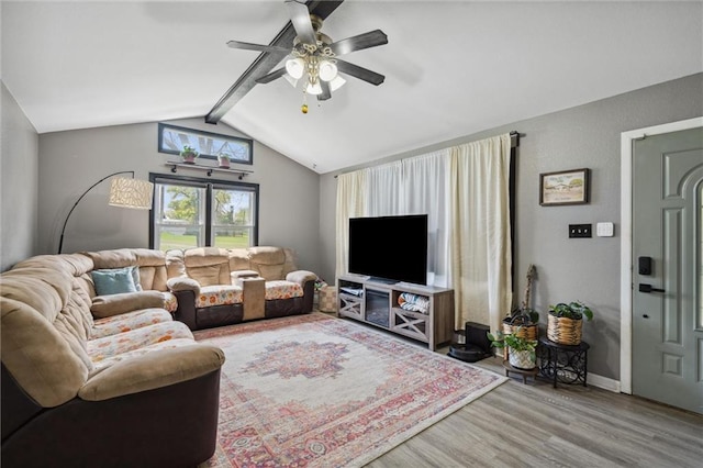 living room with baseboards, a ceiling fan, wood finished floors, and vaulted ceiling with beams