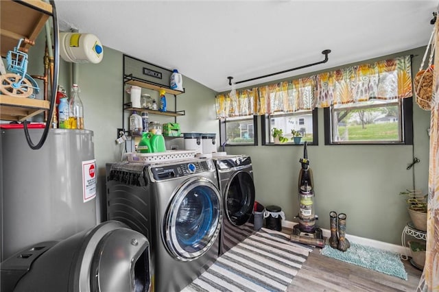 washroom featuring water heater, laundry area, wood finished floors, independent washer and dryer, and baseboards