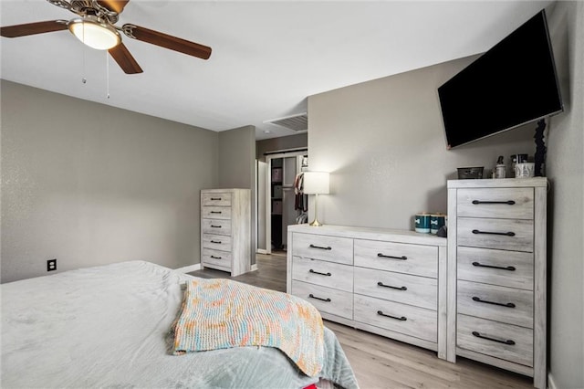 bedroom with ceiling fan, baseboards, visible vents, and light wood-style flooring