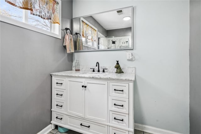 bathroom featuring baseboards, vanity, and visible vents
