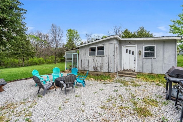view of outdoor structure with an outdoor fire pit and a sunroom