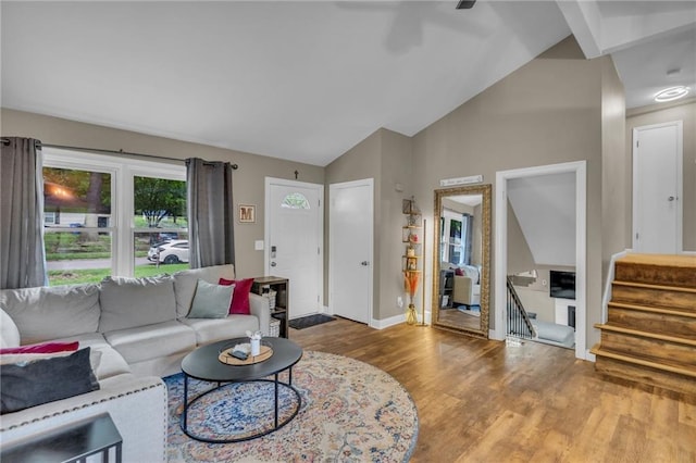 living area with stairs, baseboards, vaulted ceiling, and wood finished floors