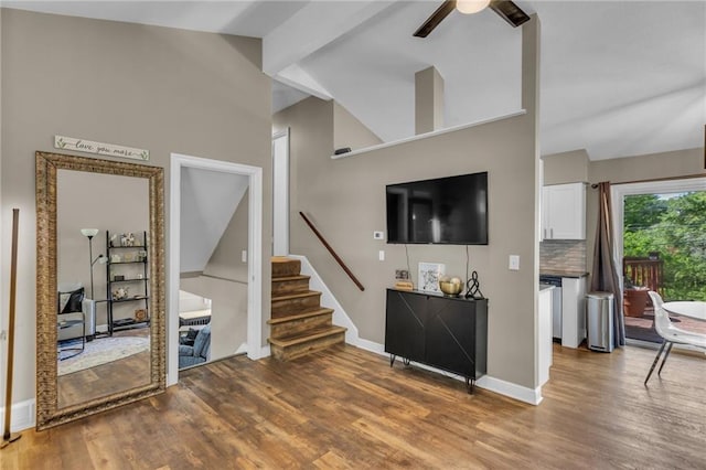 living room featuring high vaulted ceiling, stairs, a ceiling fan, baseboards, and wood finished floors