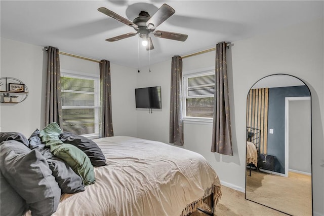bedroom featuring ceiling fan, light carpet, and baseboards