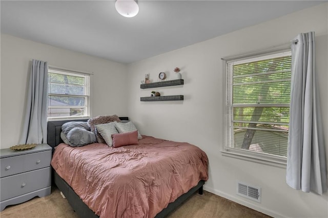 bedroom with visible vents and light carpet