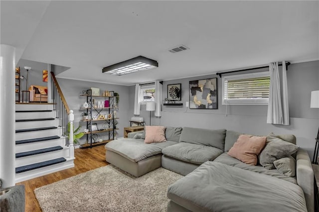 living area featuring visible vents, wood finished floors, and stairway