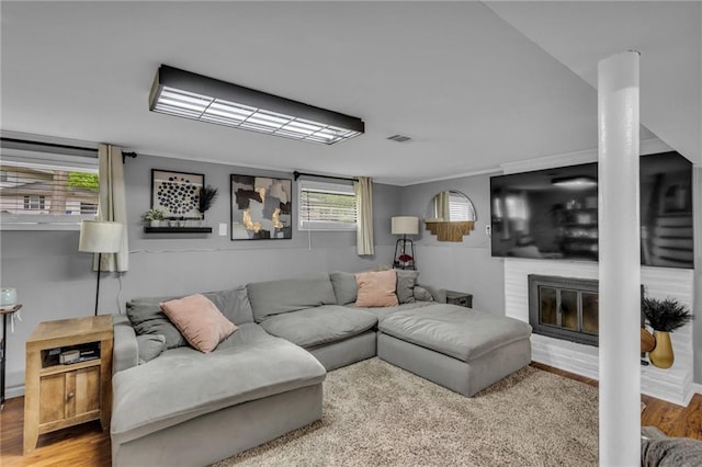 living area with a fireplace, wood finished floors, and visible vents