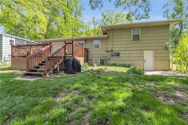 back of property with a yard, fence, stairway, and a wooden deck