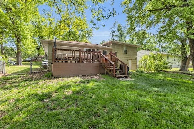 back of property with a deck, a gate, fence, a yard, and stairs