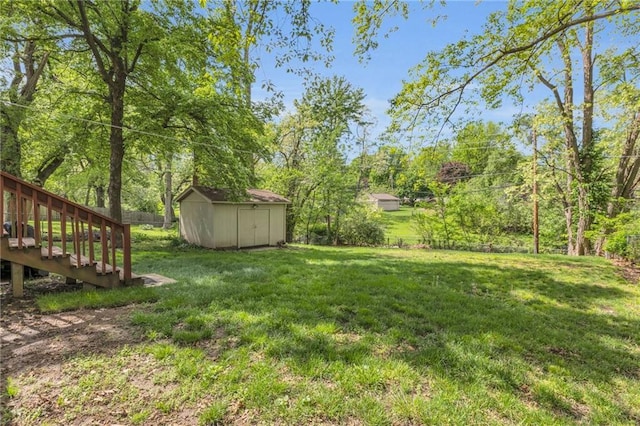 view of yard featuring fence, an outbuilding, and a shed