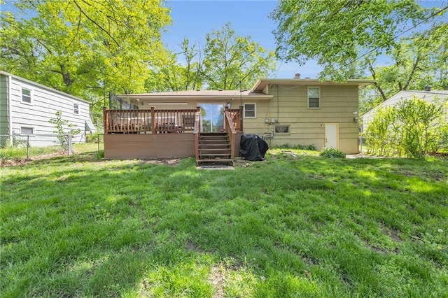 rear view of house with fence, stairs, a lawn, and a deck