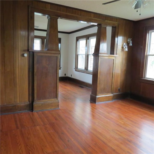 101 E 3rd St, Stanberry, MO 64489 - interior space with ornate columns, a ceiling fan, baseboards, ornamental molding, and wood finished floors
