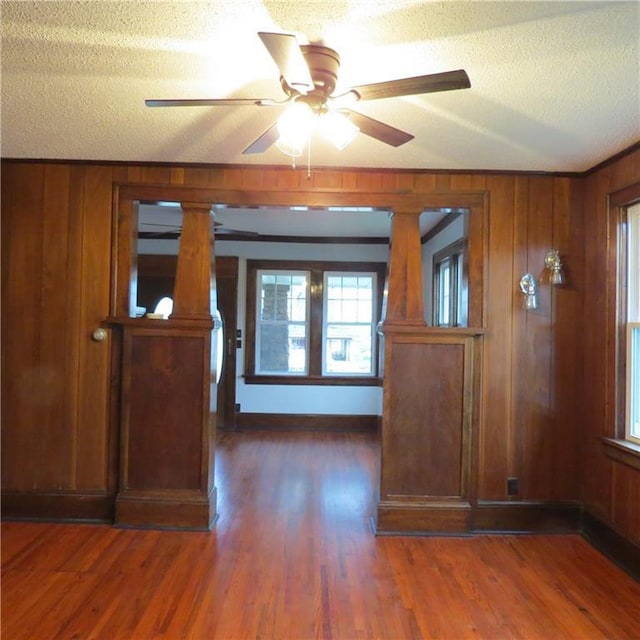 101 E 3rd St, Stanberry, MO 64489 - interior space with wood walls, wood finished floors, a wealth of natural light, and ceiling fan