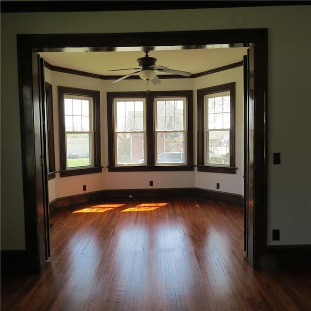 101 E 3rd St, Stanberry, MO 64489 - unfurnished room with a healthy amount of sunlight, ornamental molding, dark wood-style floors, and baseboards