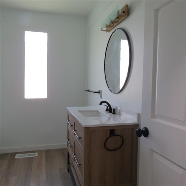 101 E 3rd St, Stanberry, MO 64489 - bathroom with wood finished floors, visible vents, vanity, and baseboards