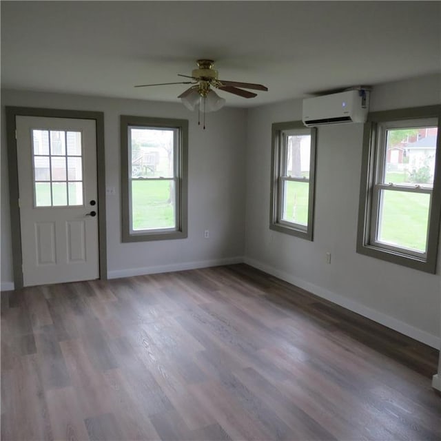 101 E 3rd St, Stanberry, MO 64489 - interior space featuring an AC wall unit, a ceiling fan, wood finished floors, and baseboards