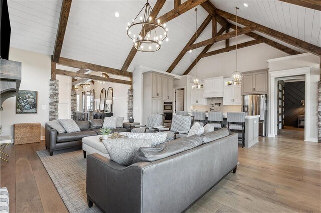 325 Ambersham Dr, Lees Summit, MO 64081 - living area featuring a chandelier, high vaulted ceiling, beamed ceiling, light wood-style floors, and baseboards