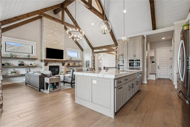 325 Ambersham Dr, Lees Summit, MO 64081 - kitchen with gray cabinetry, a sink, open floor plan, high vaulted ceiling, and appliances with stainless steel finishes