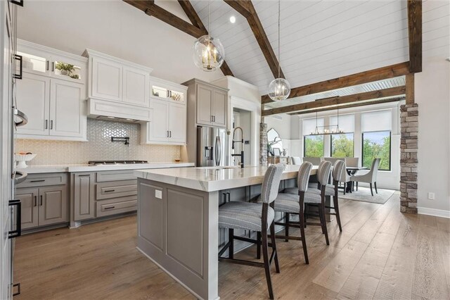 325 Ambersham Dr, Lees Summit, MO 64081 - kitchen with gray cabinetry, a sink, beamed ceiling, a chandelier, and a kitchen island with sink