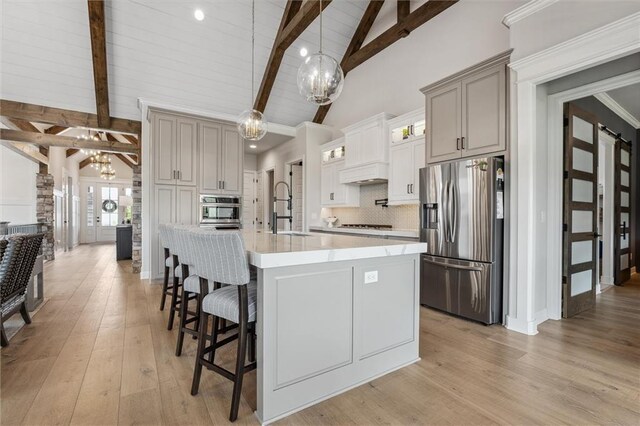 325 Ambersham Dr, Lees Summit, MO 64081 - kitchen with stainless steel appliances, a chandelier, a sink, light countertops, and a kitchen breakfast bar