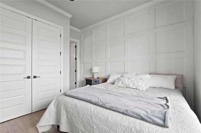 325 Ambersham Dr, Lees Summit, MO 64081 - bedroom with a decorative wall, ornamental molding, wood finished floors, and a closet