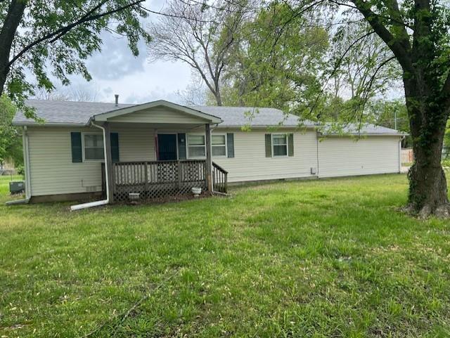 back of house featuring covered porch and a lawn
