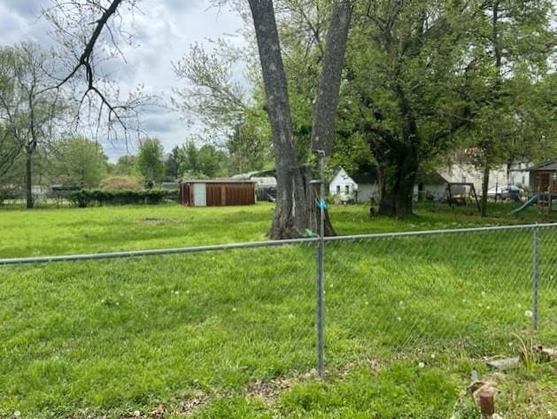 view of yard featuring fence and an outbuilding