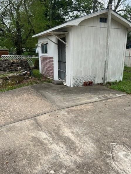view of outbuilding with fence and an outbuilding