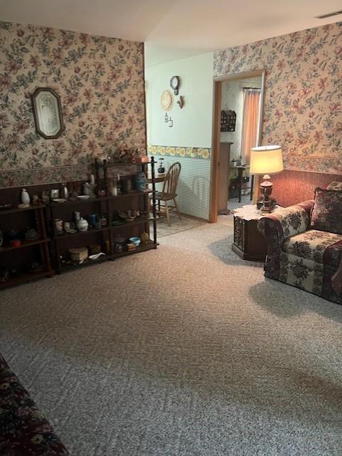 carpeted living room with wallpapered walls and visible vents