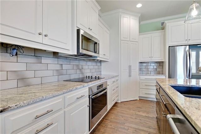 kitchen featuring appliances with stainless steel finishes, white cabinetry, recessed lighting, light wood-type flooring, and decorative backsplash