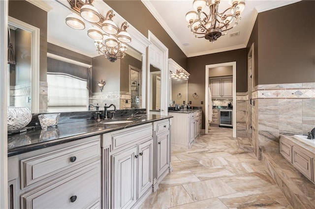 full bathroom with wine cooler, crown molding, two vanities, and a notable chandelier