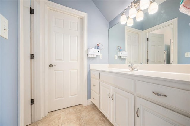 bathroom with vanity, tile patterned flooring, and lofted ceiling