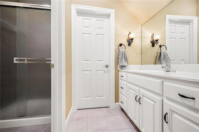 full bath featuring vanity, tile patterned floors, baseboards, a shower stall, and lofted ceiling