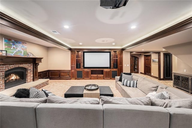 carpeted home theater with recessed lighting, ornamental molding, wainscoting, and a fireplace