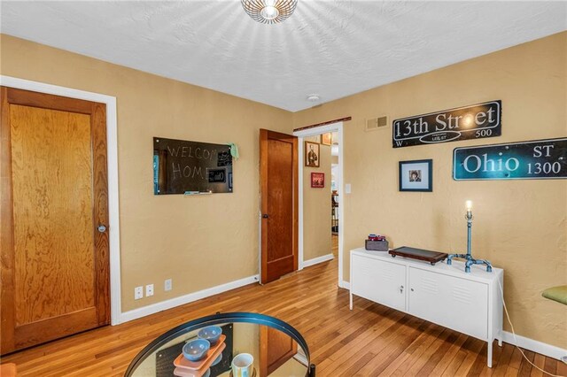playroom featuring light wood-style flooring and baseboards