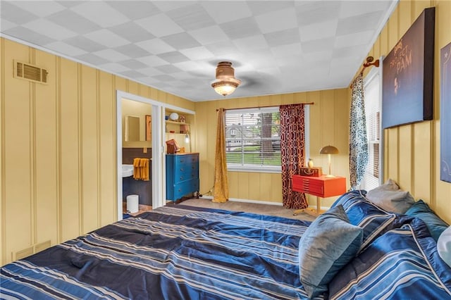 bedroom featuring a decorative wall and carpet