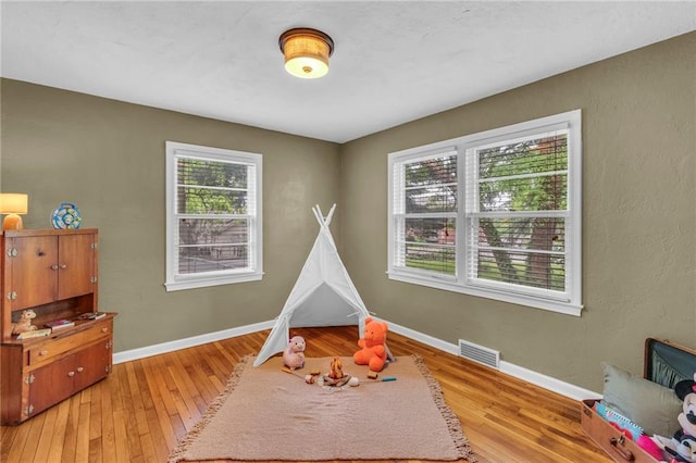 rec room featuring light wood-type flooring and baseboards