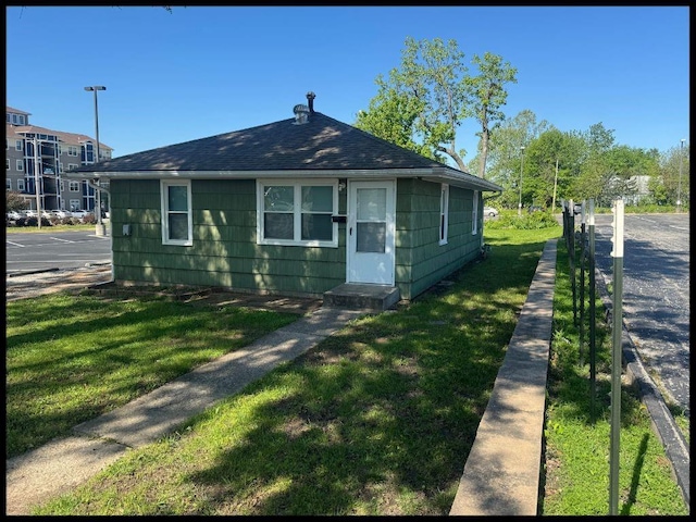 708 Highland Ave, Warrensburg, MO 64093 - bungalow featuring fence, a shingled roof, and a front lawn