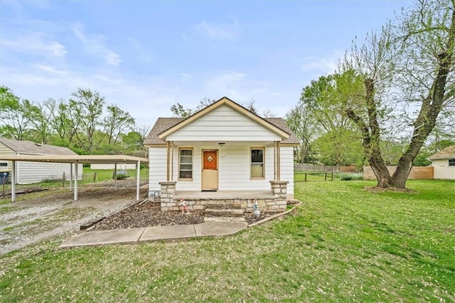 6425 N Edison Ave, Kansas City, MO 64151 - view of front of property featuring driveway, a detached carport, fence, a porch, and a front lawn