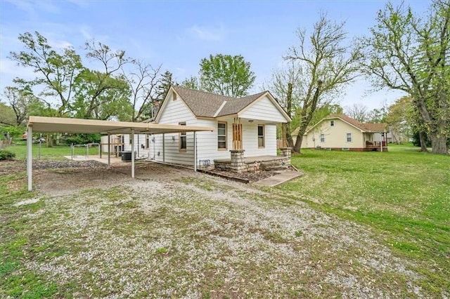 6425 N Edison Ave, Kansas City, MO 64151 - rear view of house featuring a yard, driveway, and a detached carport