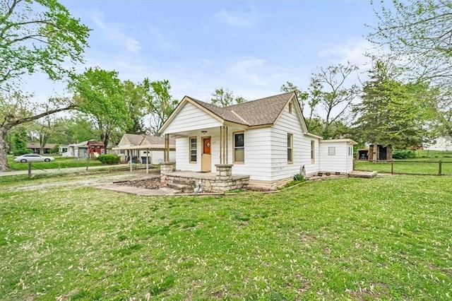 6425 N Edison Ave, Kansas City, MO 64151 - view of front of home with a front lawn, a shingled roof, covered porch, and fence