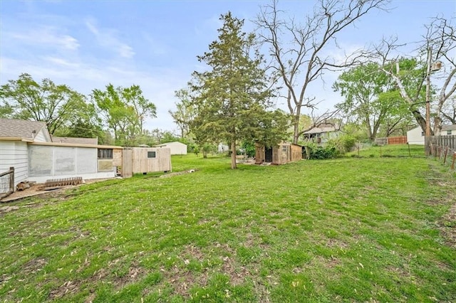 6425 N Edison Ave, Kansas City, MO 64151 - view of yard featuring a storage unit, fence, and an outbuilding