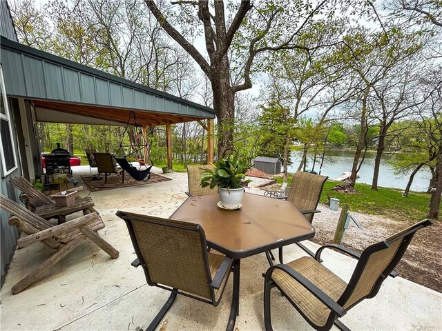 58 E Sugar Lake Cv, Mound City, KS 66056 - view of patio / terrace with outdoor dining area and a water view